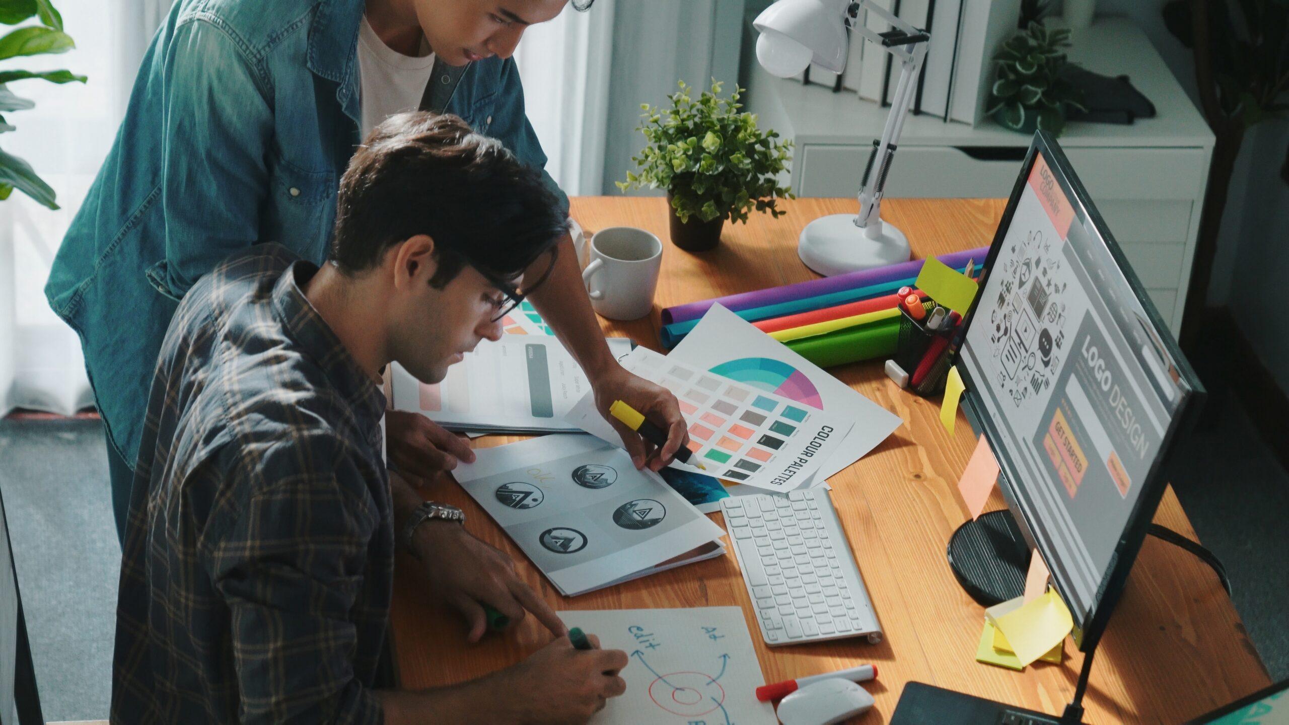 Two colleagues working together on a computer at a desk, concentrating on their project.
