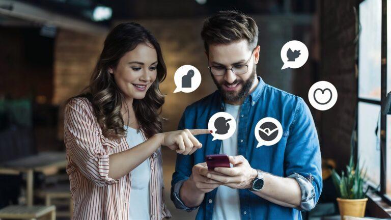 female friend pointing man using social media network notification icons mobile scaled